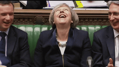 A Woman In A Suit Is Laughing While Sitting Next To Two Men GIF