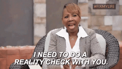 A Woman In A Suit Is Sitting In A Chair And Saying `` I Need To Do A Reality Check With You '' . GIF