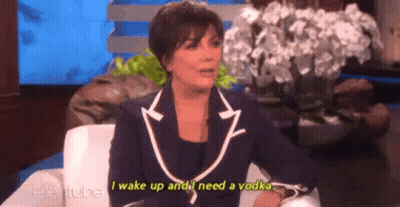 A Woman In A Suit Is Sitting In A Chair On A Talk Show And Talking About A Vodka . GIF