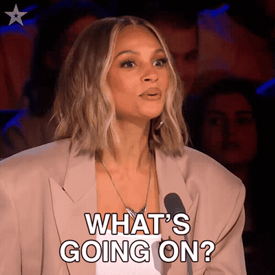 A Woman In A Suit Says What 'S Going On In Front Of A Microphone GIF