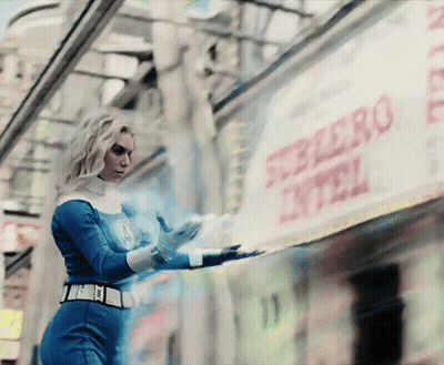A Woman In A Superhero Costume Is Standing In Front Of A Sign That Says Ferrero GIF