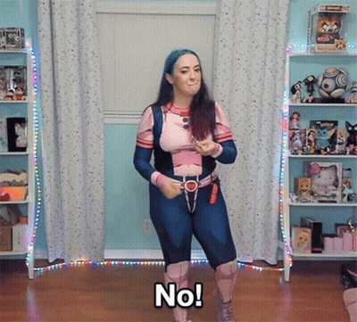 A Woman In A Superhero Costume Says No While Dancing GIF
