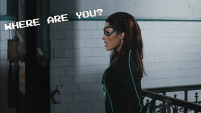 A Woman In A Superhero Costume Stands In Front Of A Sign That Says " Where Are You " GIF
