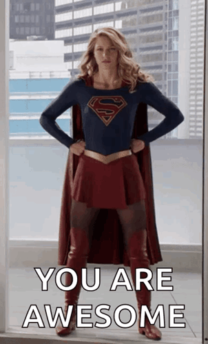 A Woman In A Superman Costume Is Standing In Front Of A Window With Her Hands On Her Hips And Says You Are Awesome . GIF