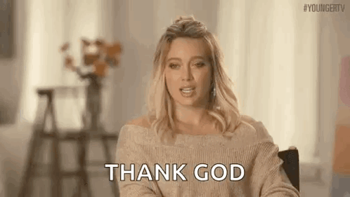 A Woman In A Sweater Is Giving A Thank God Sign . GIF