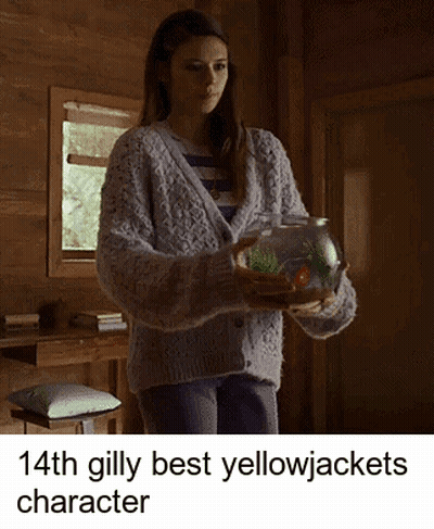 A Woman In A Sweater Is Holding A Fish In A Bowl GIF