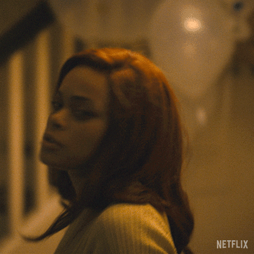 A Woman In A Sweater Says " Never " In White Letters GIF