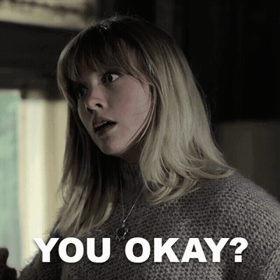 A Woman In A Sweater Says " You Okay " In Front Of Her GIF