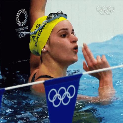 A Woman In A Swimming Pool Wearing A Yellow Cap That Says Mckeown On It GIF