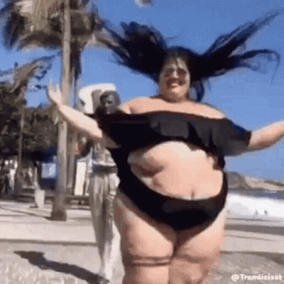 A Woman In A Swimsuit Is Dancing On The Beach . GIF
