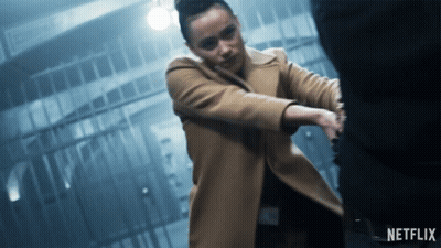 A Woman In A Tan Coat Is Holding A Man 'S Hand With A Netflix Logo In The Corner GIF