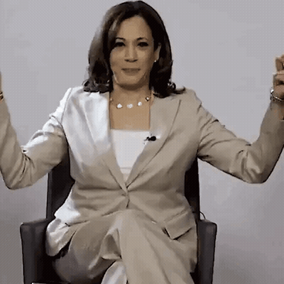 A Woman In A Tan Suit Is Sitting In A Chair With Her Arms Outstretched . GIF