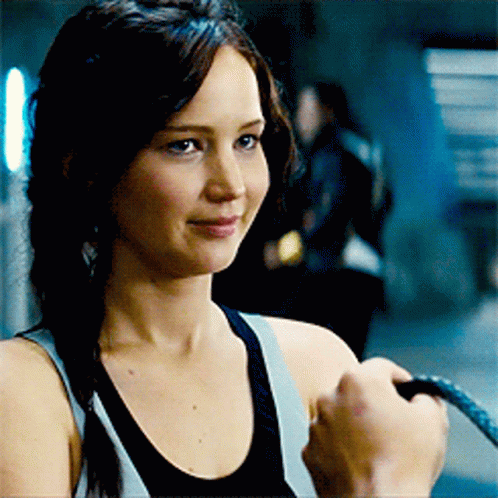 A Woman In A Tank Top Is Holding A Rope GIF