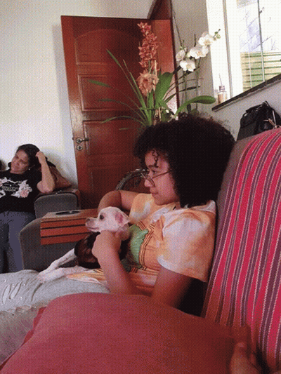 A Woman In A Tie Dye Shirt Is Petting A Small White Dog GIF