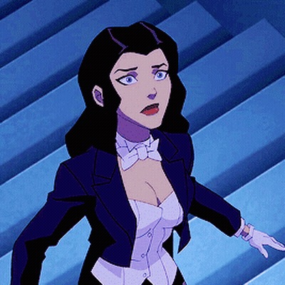 A Woman In A Tuxedo And Bow Tie Is Standing In Front Of Stairs GIF