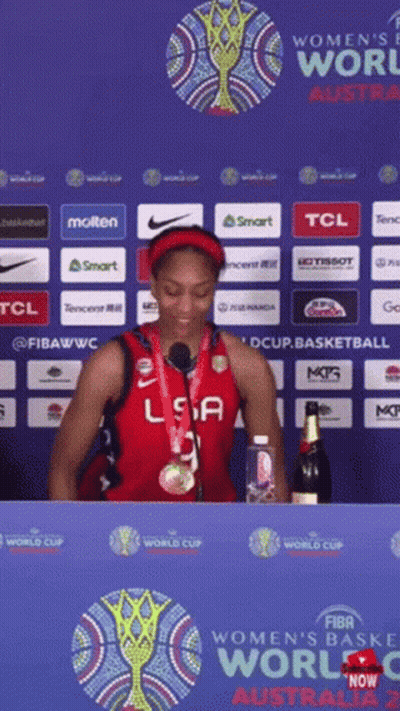 A Woman In A Usa Jersey Stands In Front Of A Sign That Says Women 'S World Cup Australia 2 GIF