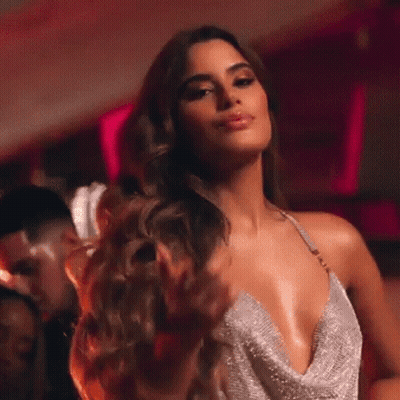 A Woman In A Very Plunging Dress Is Dancing In A Nightclub . GIF