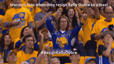 A Woman In A Warriors Sweater Stands In A Crowd GIF