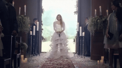 A Woman In A Wedding Dress Is Walking Down The Aisle In A Church GIF