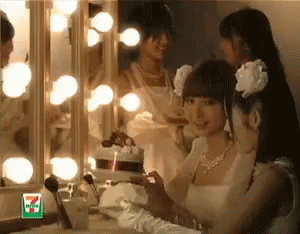 A Woman In A Wedding Dress Looks At Herself In A Mirror With A 7 Eleven Logo On It GIF