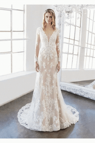 A Woman In A Wedding Dress Stands In Front Of A Mirror GIF