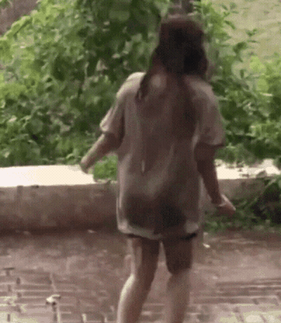 A Woman In A Wet Shirt Is Walking In The Rain GIF