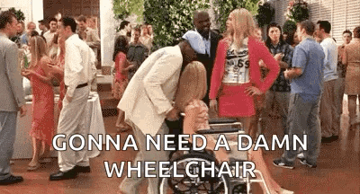 A Woman In A Wheelchair Is Being Pushed By A Man In A Suit . GIF