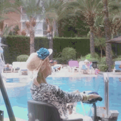 A Woman In A Wheelchair Sits By A Swimming Pool GIF