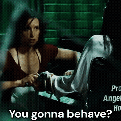 A Woman In A Wheelchair Talks To Another Woman Who Is Tied Up GIF