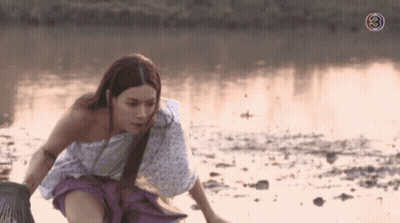 A Woman In A White And Purple Dress Is Kneeling In The Water With The Number 3 Behind Her GIF