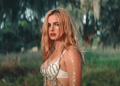 A Woman In A White Bra With Pearls Around Her Neck GIF