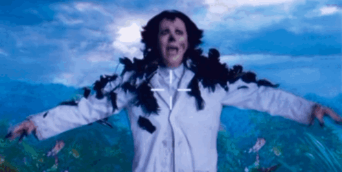 A Woman In A White Coat With A Cross On Her Chest GIF