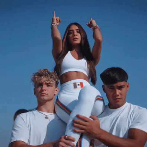 A Woman In A White Crop Top Is Being Carried On The Shoulders Of Two Men GIF