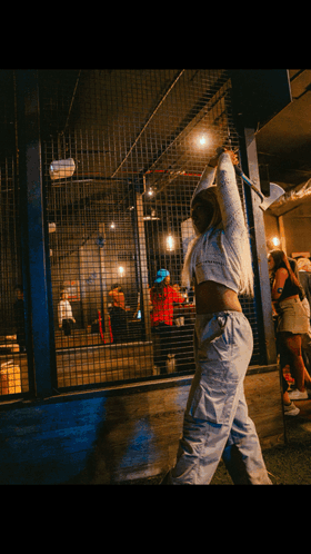 A Woman In A White Crop Top Is Holding An Axe Over Her Head GIF