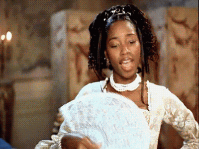 A Woman In A White Dress Holding A Fan GIF