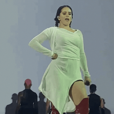 A Woman In A White Dress Holds A Microphone In Her Hand GIF