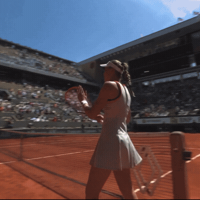 A Woman In A White Dress Holds A Tennis Racquet On A Tennis Court GIF