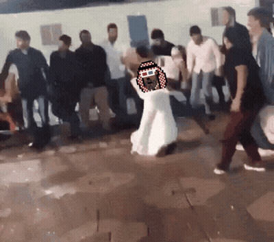A Woman In A White Dress Is Dancing In A Crowd Of People GIF