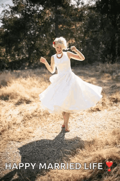 A Woman In A White Dress Is Dancing In A Field With The Text Happy Married Life GIF