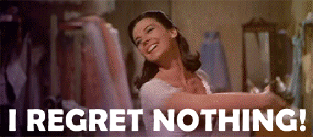 A Woman In A White Dress Is Dancing In A Room With The Words `` I Regret Nothing '' Written Below Her . GIF
