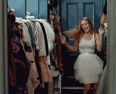 A Woman In A White Dress Is Dancing In Front Of A Closet With A Sign That Says Om GIF