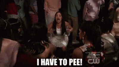 A Woman In A White Dress Is Dancing In Front Of A Crowd And Says I Have To Pee ! GIF