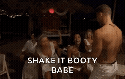 A Woman In A White Dress Is Dancing In Front Of A Group Of People And A Man . GIF