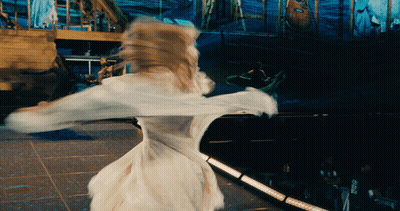 A Woman In A White Dress Is Dancing On A Stage In Front Of A Sign That Says ' Pepsi ' GIF