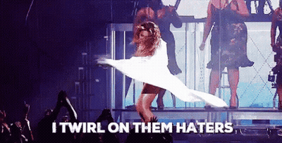 A Woman In A White Dress Is Dancing On A Stage With The Words I Twirl On Them Haters Written Below Her GIF