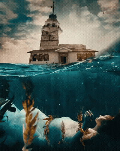 A Woman In A White Dress Is Floating In The Ocean GIF