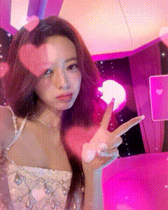 A Woman In A White Dress Is Giving A Peace Sign . GIF