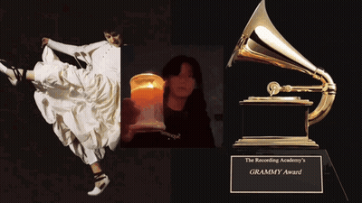 A Woman In A White Dress Is Holding A Candle And A Grammy Award GIF
