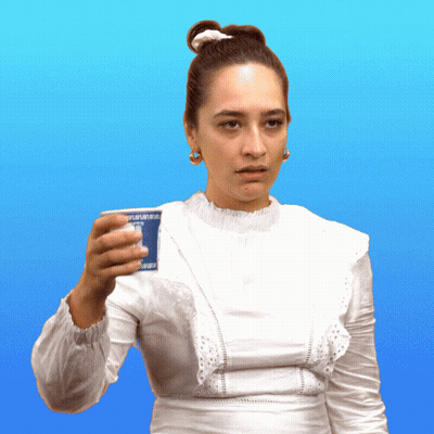 A Woman In A White Dress Is Holding A Cup That Says " Yogurt " GIF