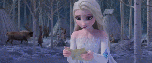 A Woman In A White Dress Is Holding A Piece Of Paper That Says ' I Love You ' On It GIF